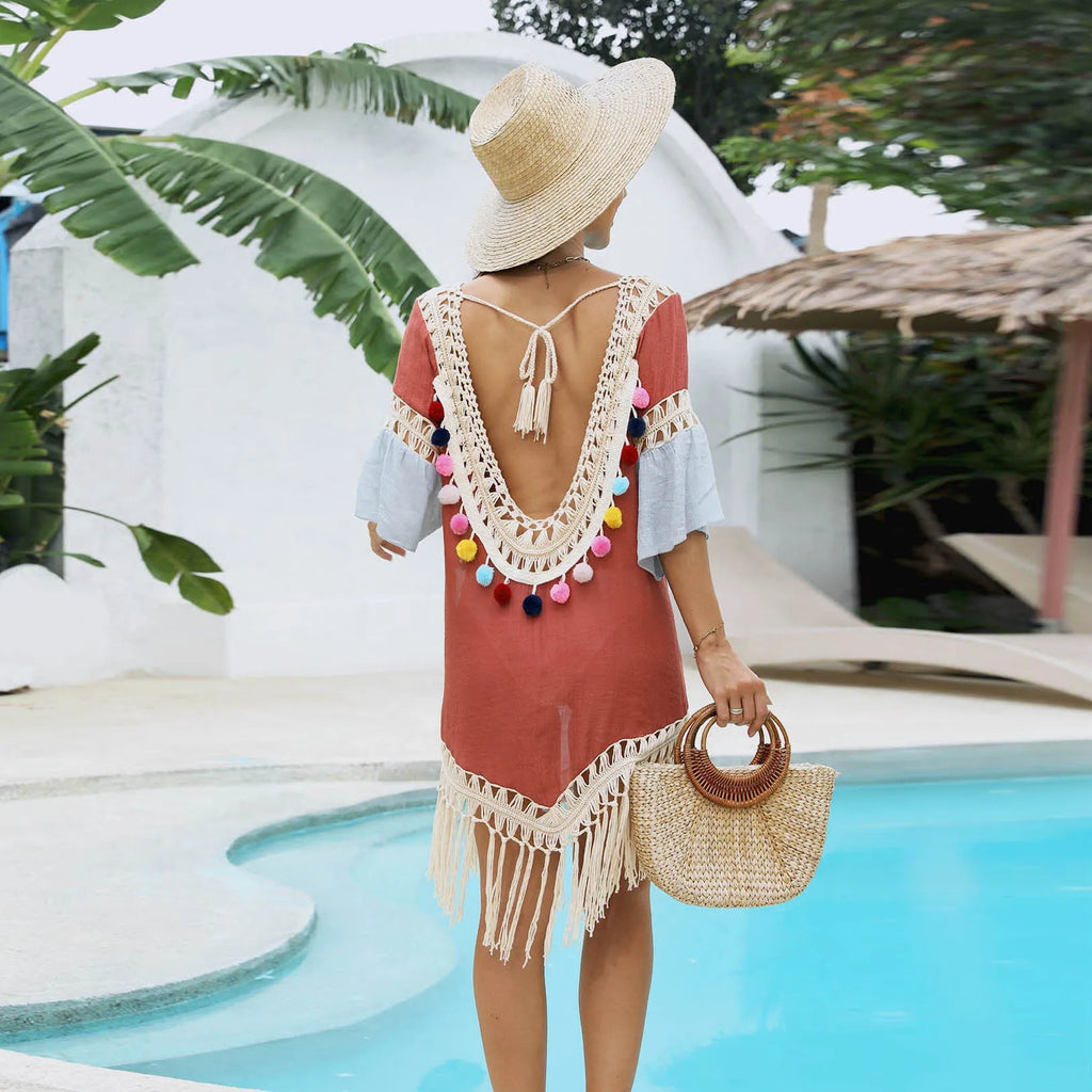 Orange floral patterned beach overskirt with hand-crochet detail and tassels, laid flat.
