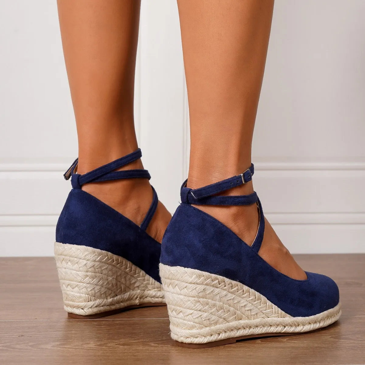 Dark blue suede straw woven wedge closed toe high heels with buckle fastening on a white background