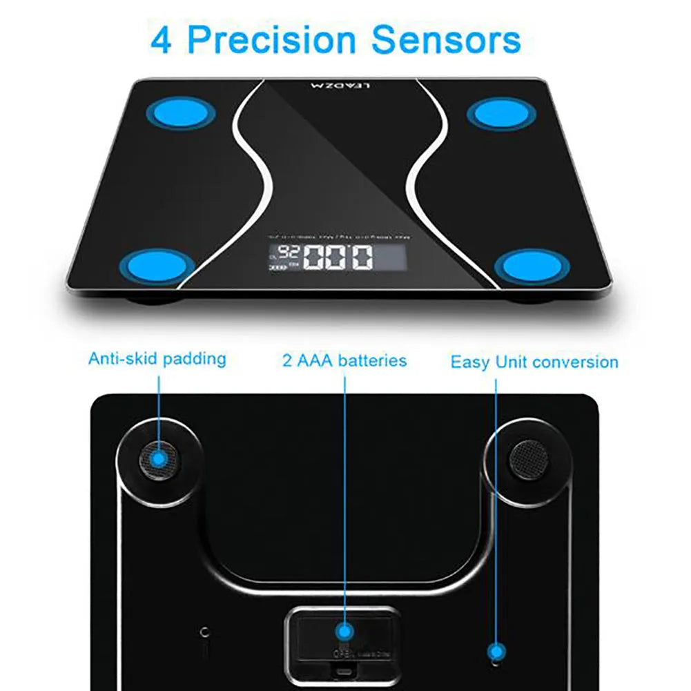Black digital electronic bathroom scale with tempered glass platform on a bathroom floor.