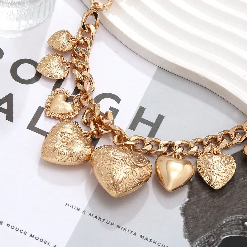 Gold-coloured carved heart pendant necklace on an adjustable metal chain.