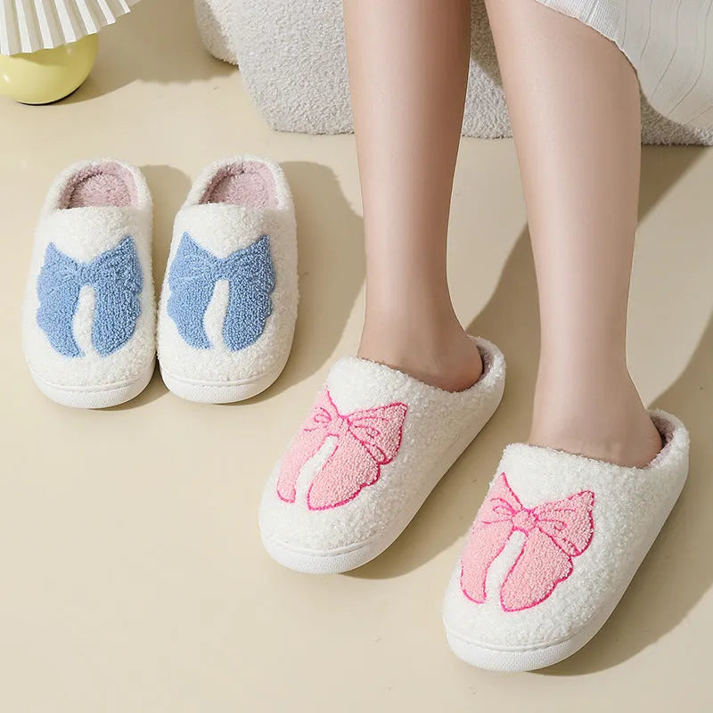 A pair of pink cartoon bow knot suede slippers with a TPR sole, shown from the side.