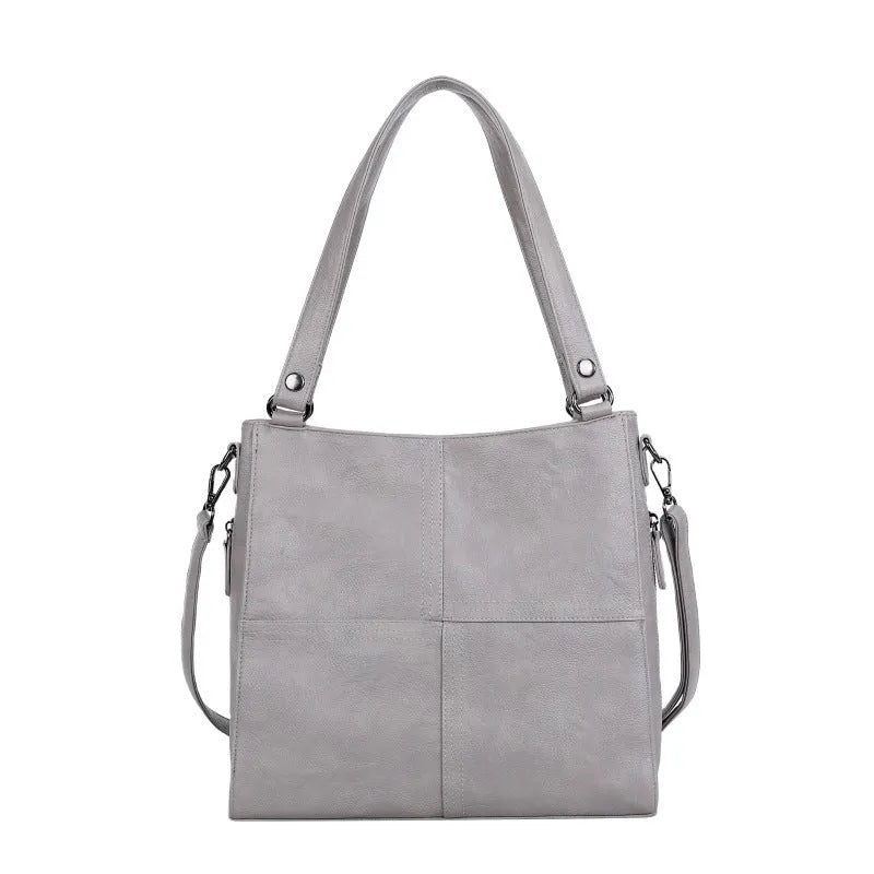 Soft PU leather crossbody handbag with barrel shape and vintage styling in light khaki colour