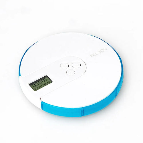 Blue weekly pill organiser with seven compartments, a digital clock display, and clear lids on a wooden table.