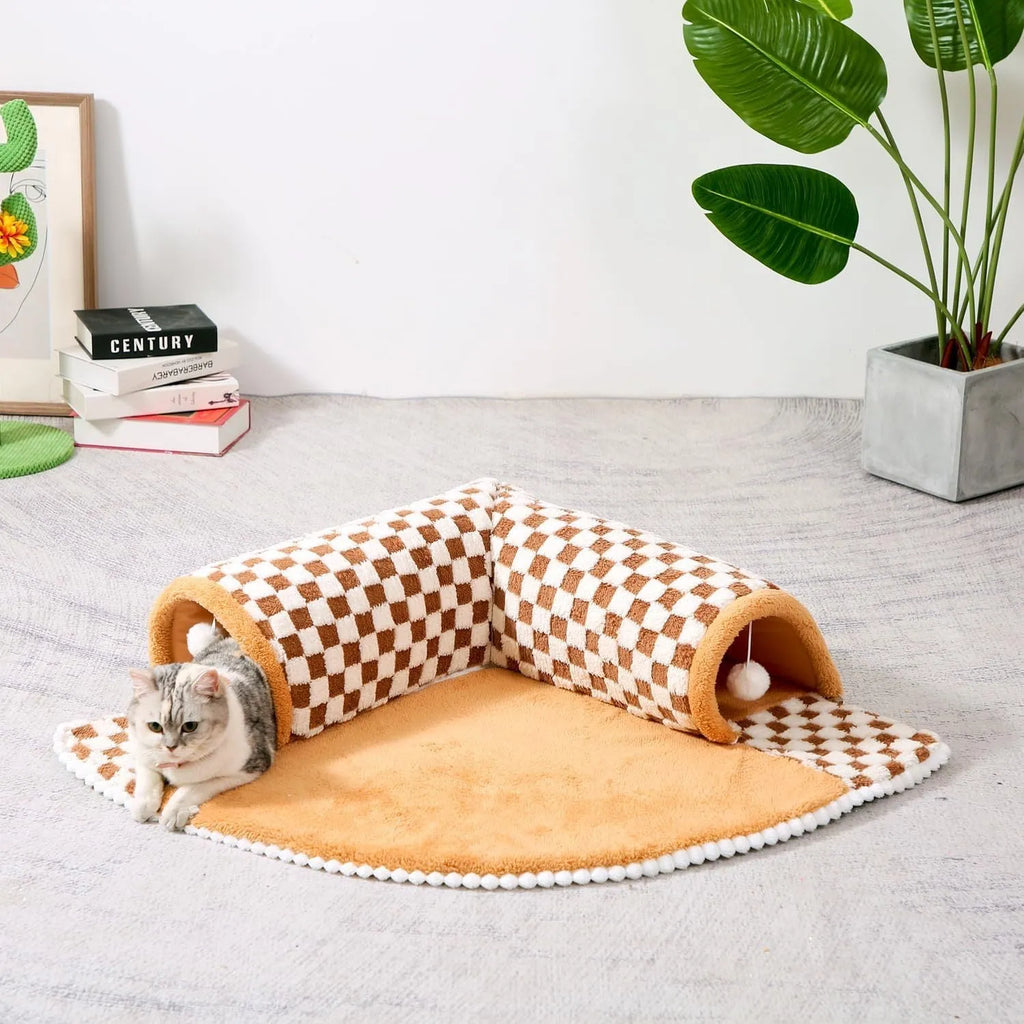 XL fan-shaped plush pet bed with a tunnel, in a plaid coffee colour, on a wooden floor.