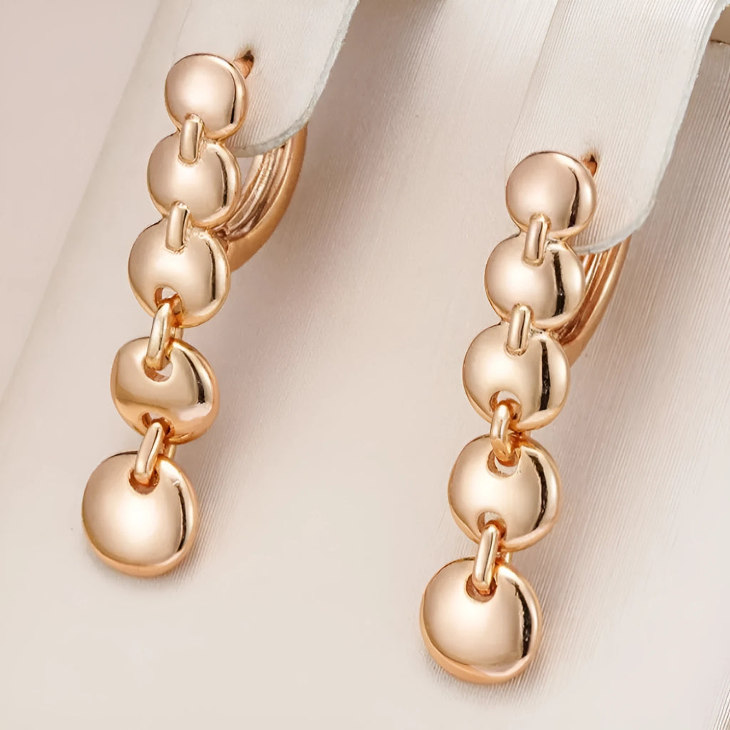 A pair of long, round circle-shaped retro earrings in a gold colour, made from woven copper