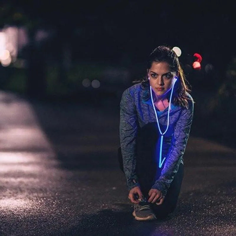 Blue wired LED light-up earphones with 3.5mm plug and inline remote control on a dark background.