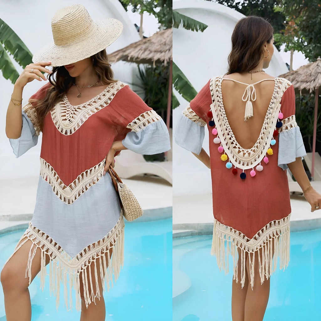 Orange floral patterned beach overskirt with hand-crochet detail and tassels, laid flat.