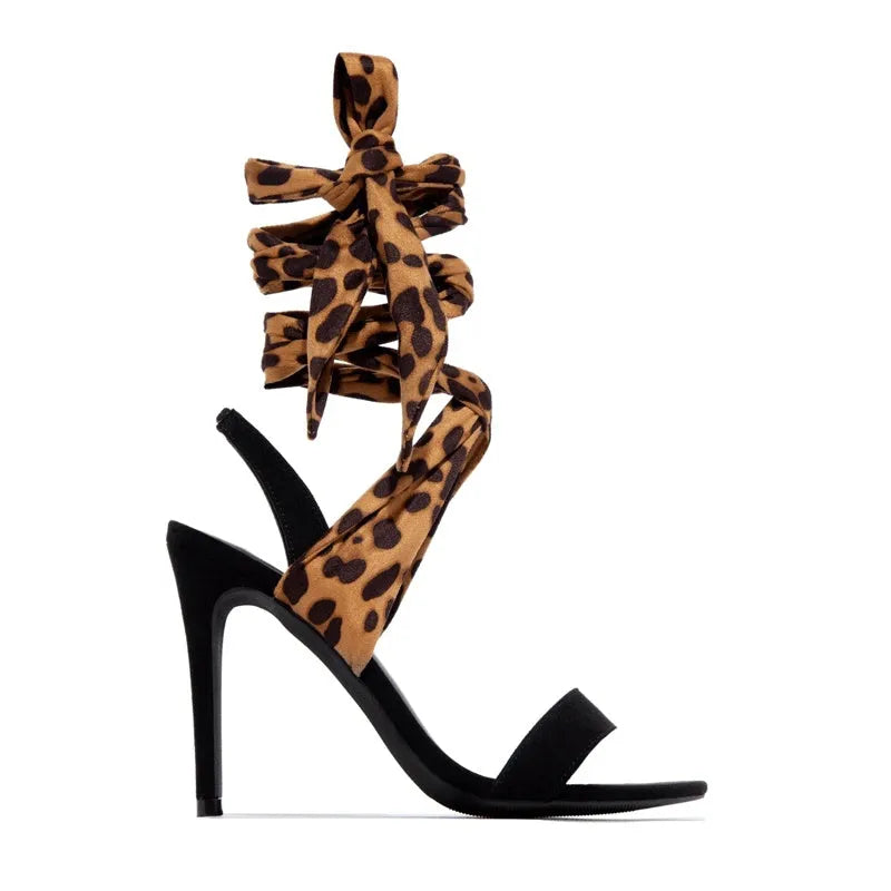 Light brown leopard print women's high heel sandals with cross-straps and a thin 8cm stiletto heel on a rubber sole.