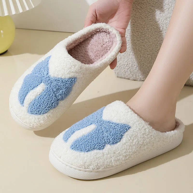 A pair of pink cartoon bow knot suede slippers with a TPR sole, shown from the side.