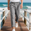Men's light khaki linen casual trousers with drawstring waist on a hanger.