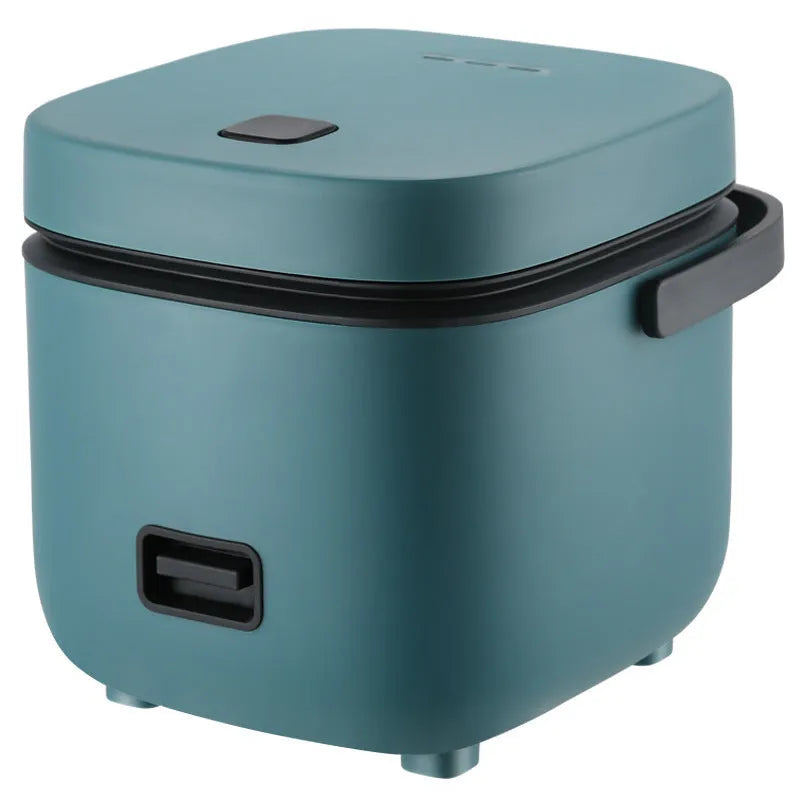 Green mini rice cooker 1.2L with steaming plate, rice spoon and measuring cup on countertop
