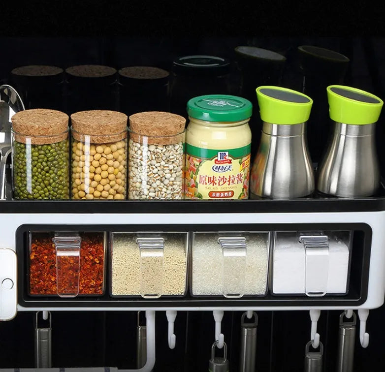 White plastic multi-function wall-mounted kitchen storage rack holding utensils and seasoning bottles