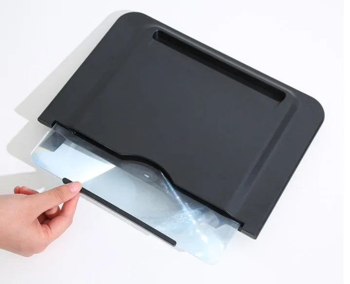 Black 12-inch mobile phone screen amplifier with pull-out stand on a table next to a phone.