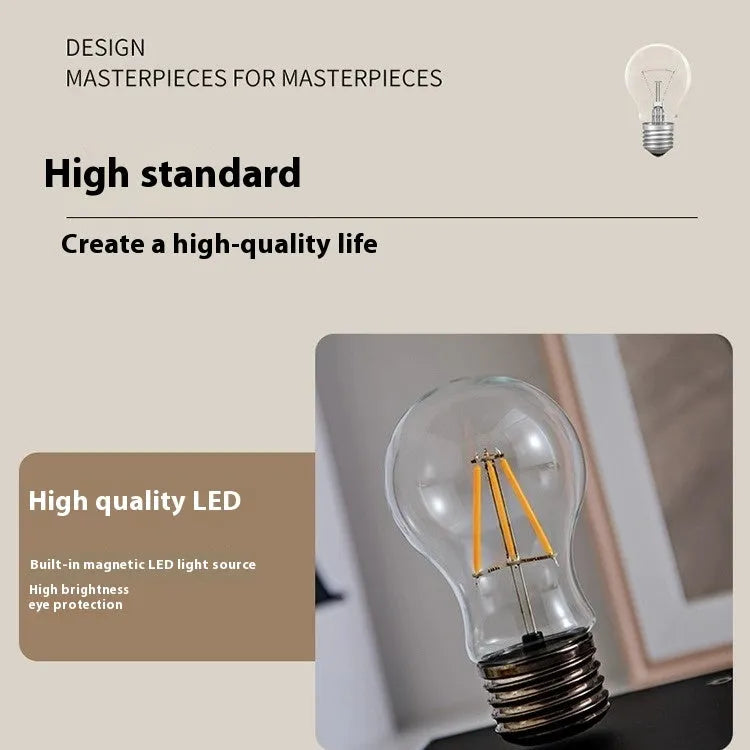 Black iron art suspension bulb decorative night lamp on a wooden desktop.