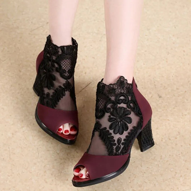Lucyever women's black gladiator sandals with floral lace upper, square heel, and peep toe on a foot.