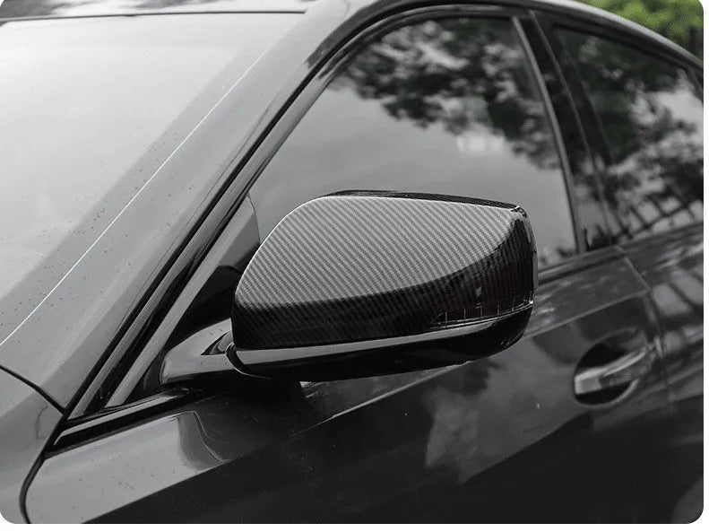 Set of ABS plastic mirror covers for Cadillac CT5 and CT6 in carbon fibre, silver, and rain frame finishes.