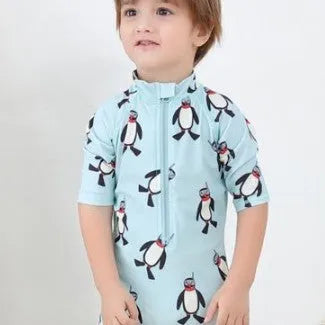 Boy's penguin print long sleeve swim shirt and matching cap set for sun protection.