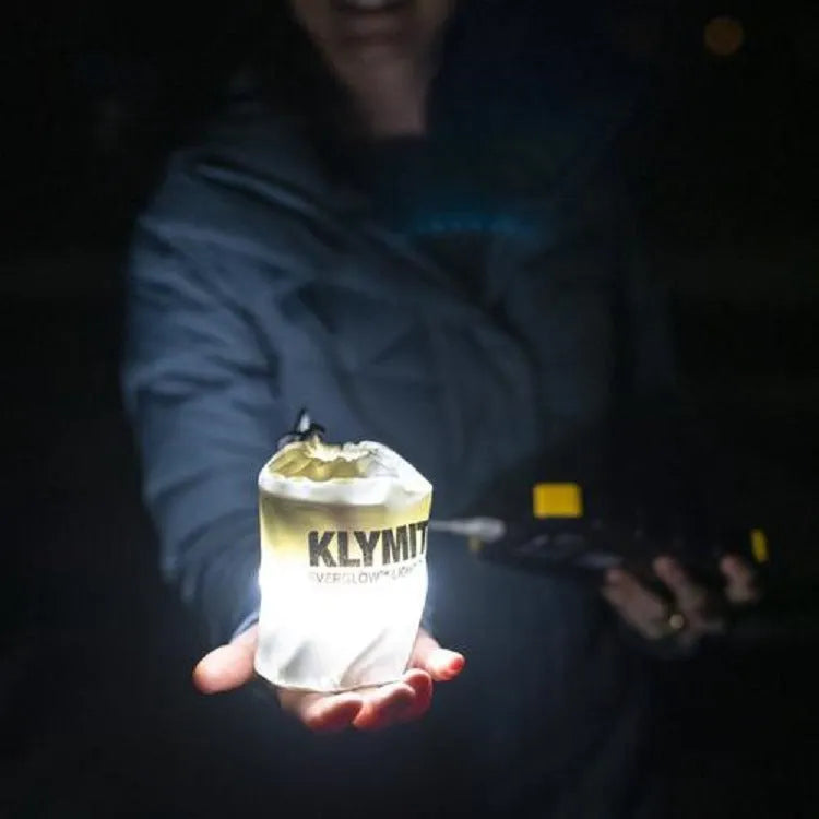 Portable inflatable folding USB LED lamp in army green, 65cm size, on a camping table.