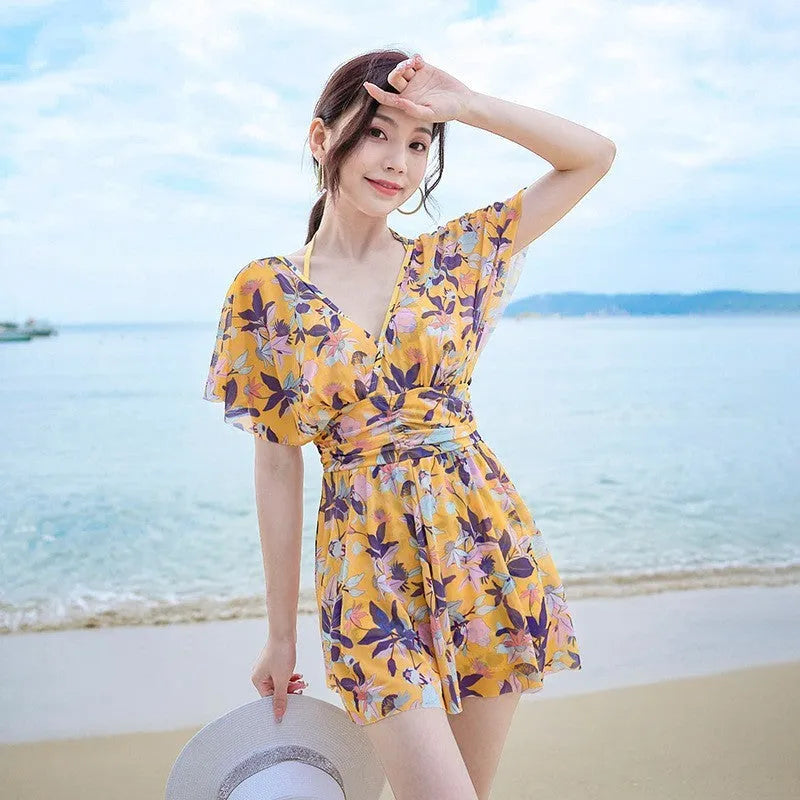 Yellow women's one-piece swimsuit with floral pattern on polyester fabric.