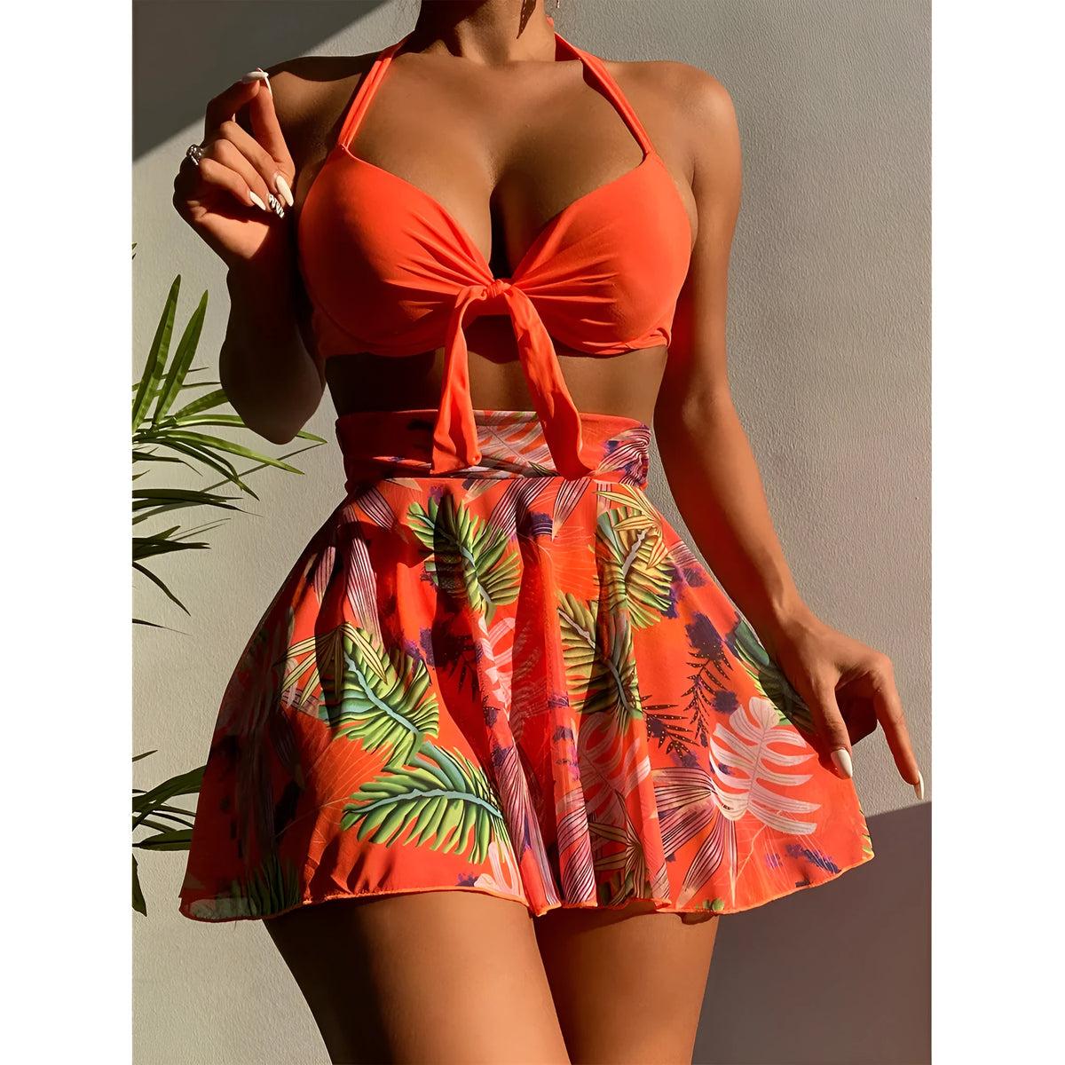 Printed three-piece polyester beach dress bikini set with skirt in orange, shown on model