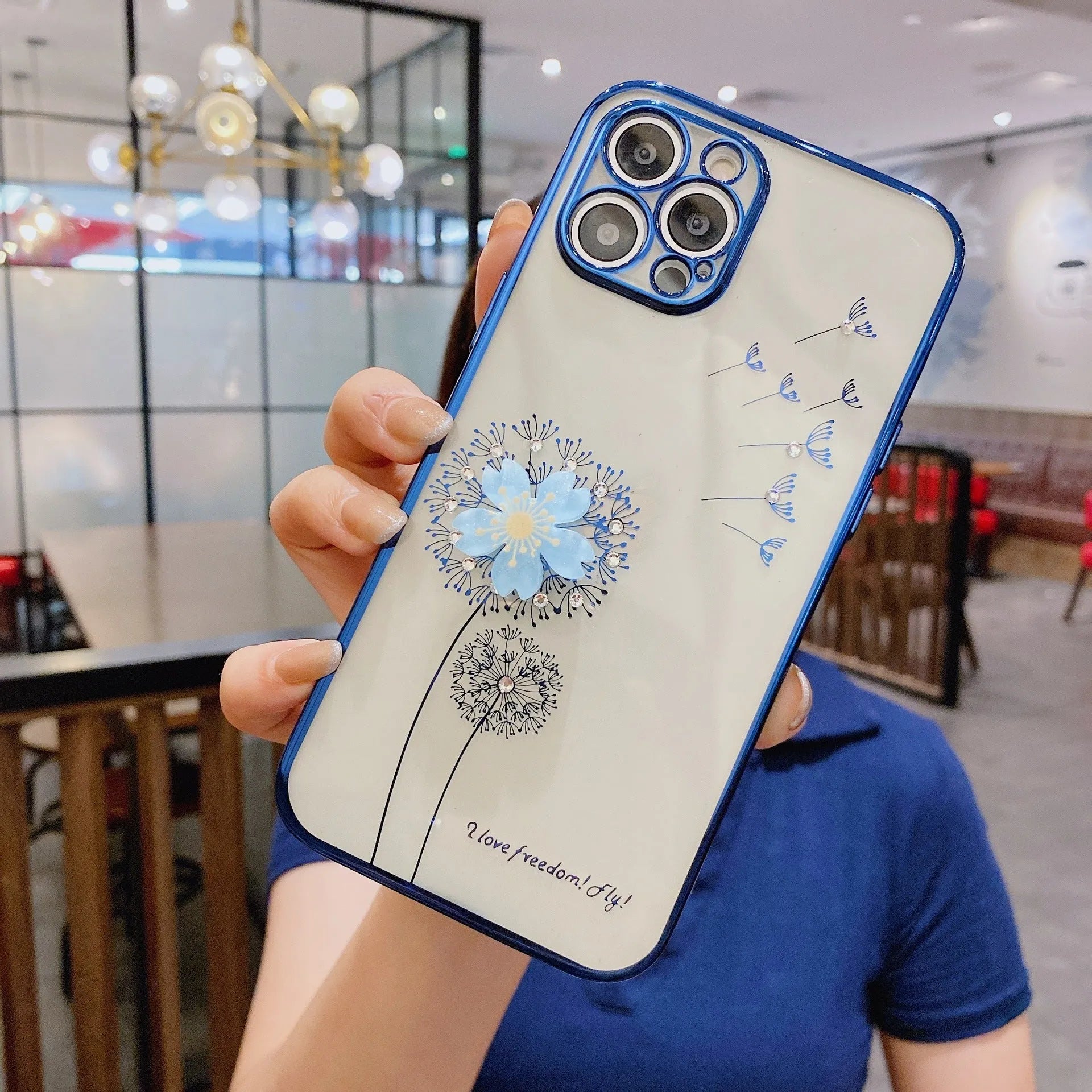 Green iPhone case with 3D white floral design and a silver rotating kickstand extended from the back.