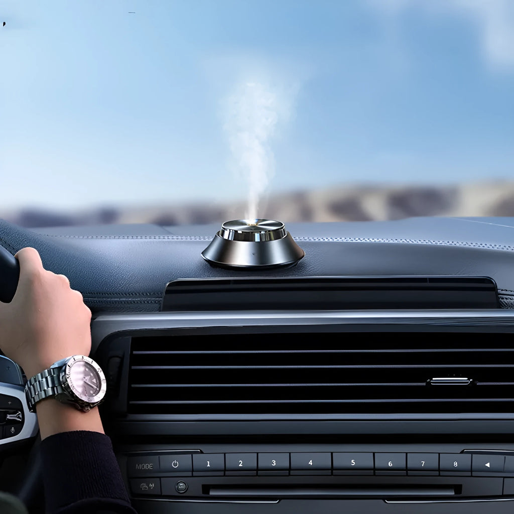 Black metal butterfly-style car aromatherapy machine with USB cable and bottle of essential oil
