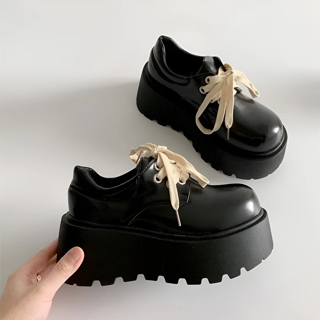 Matte black women's lace-up ankle boots with a chunky heel and buckle strap.