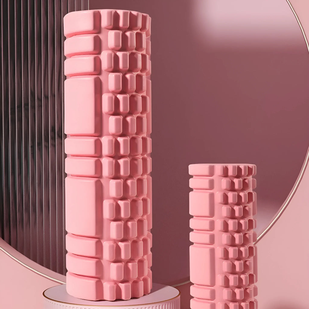 A solid black EVA foam roller on a gym floor, showing its cylindrical shape and texture.