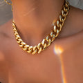 Gold thick chain women's necklace with large links, shown from the side on a plain background.