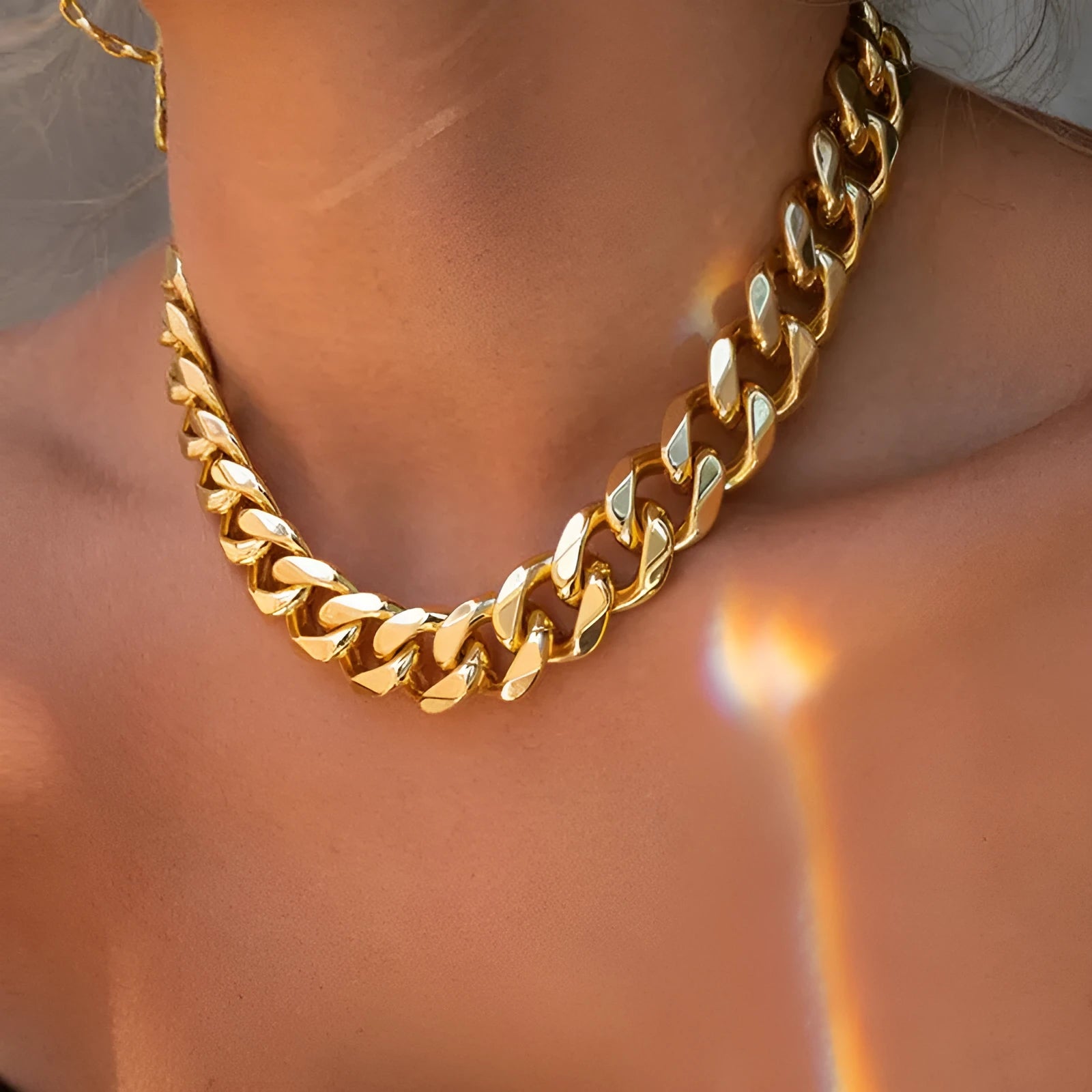 Gold thick chain women's necklace with large links, shown from the side on a plain background.