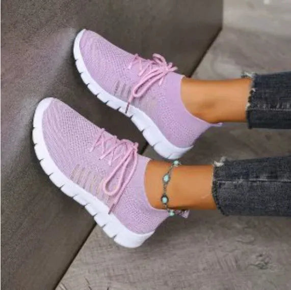 Beige ladies flying knit flat shoes with mesh upper, round toe, and low heel on a plain background