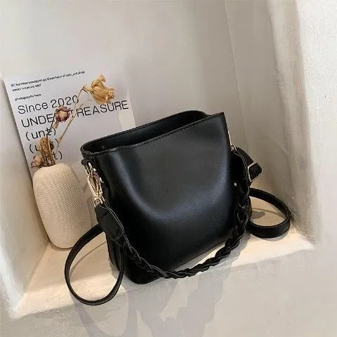 Retro khaki woven crossbody bucket bag with adjustable strap shown worn on shoulder