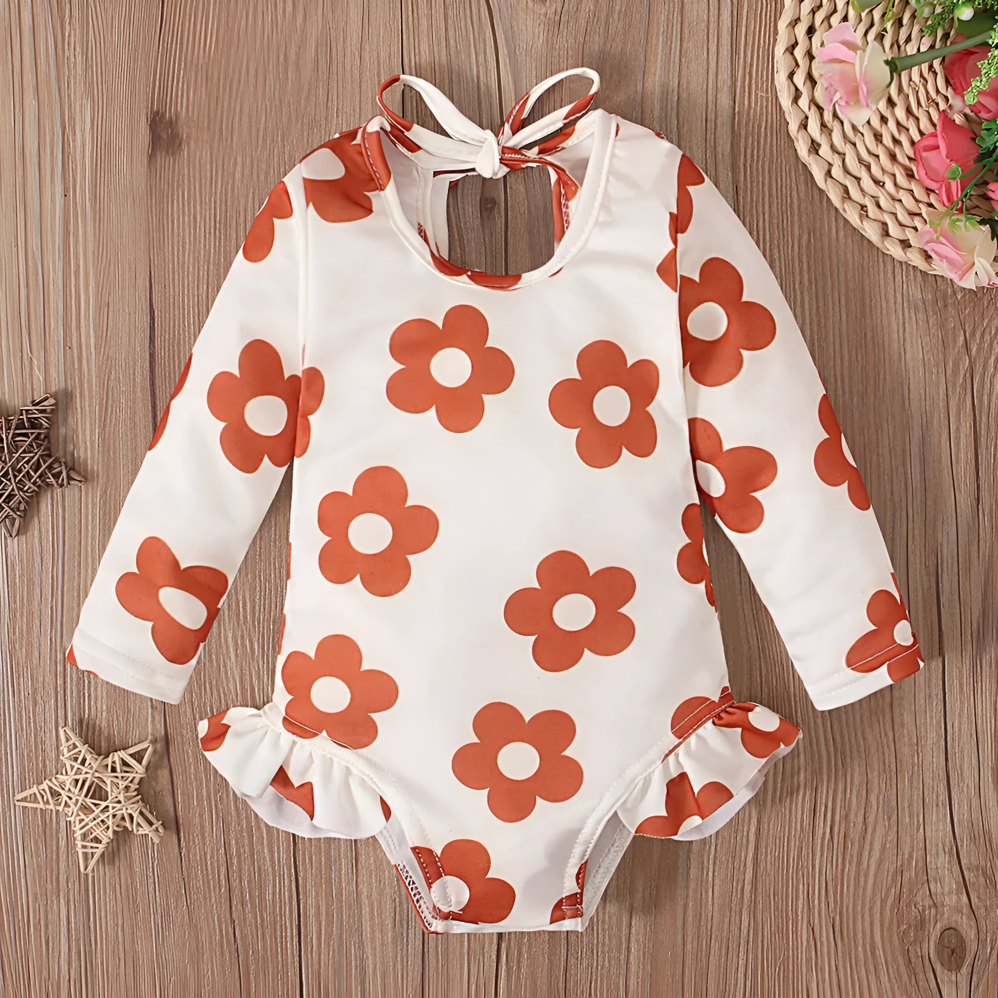 Girl's floral print open back swimsuit in orange, showing crew neck and briefs style.