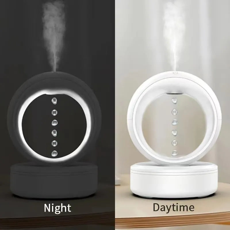 White round anti-gravity humidifier showing optical illusion of levitating water droplets on a desk.