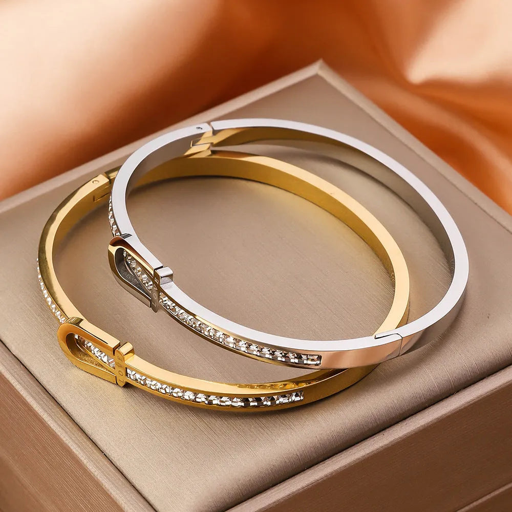 Gold plated titanium steel bangle bracelet with gang drill style, available in gold and steel colours.