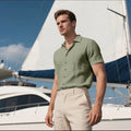 Man wearing a loose-fit grey short-sleeve linen blend shirt for casual leisure.