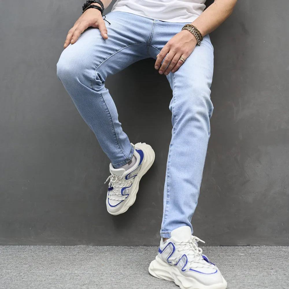 Light blue skinny cotton stretch men's jeans with mid waist and tapered leg on model