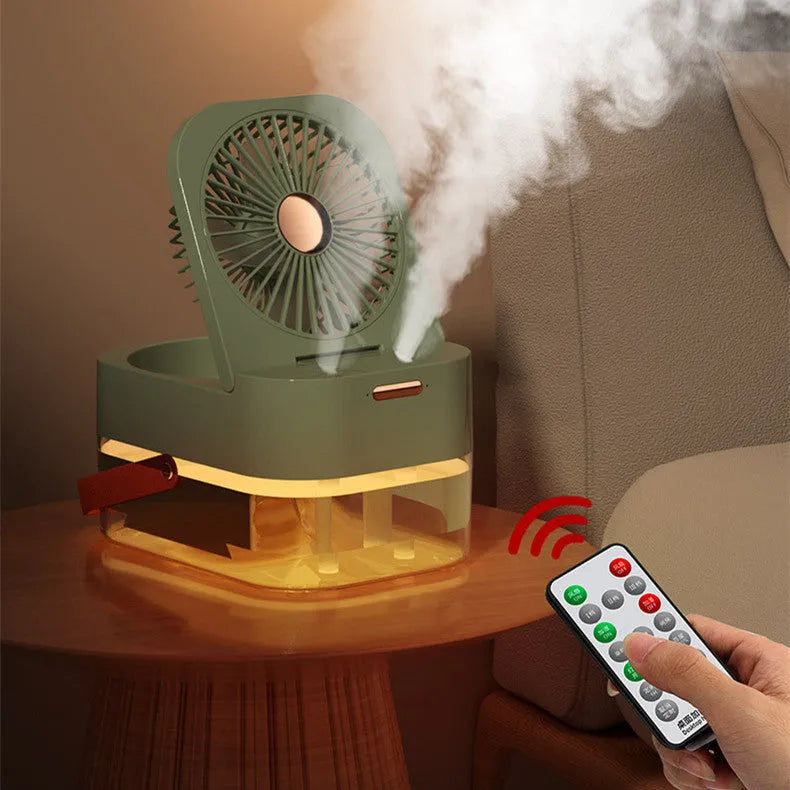 White or green USB desktop fan humidifier with remote control on a wooden desk.