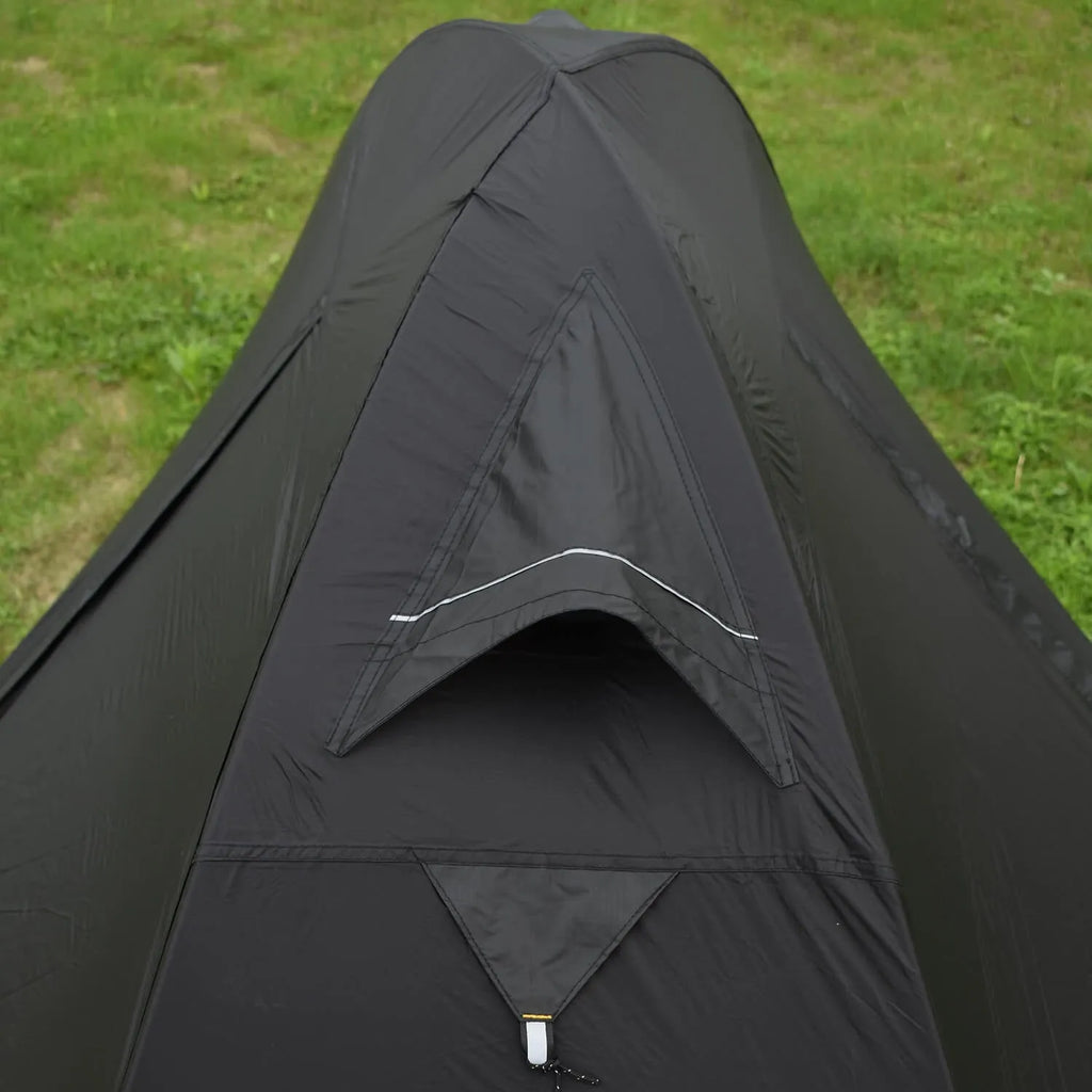 Red single-person backpacking tent with aluminium poles pitched in a forest, showing double-skin design and mesh panel.
