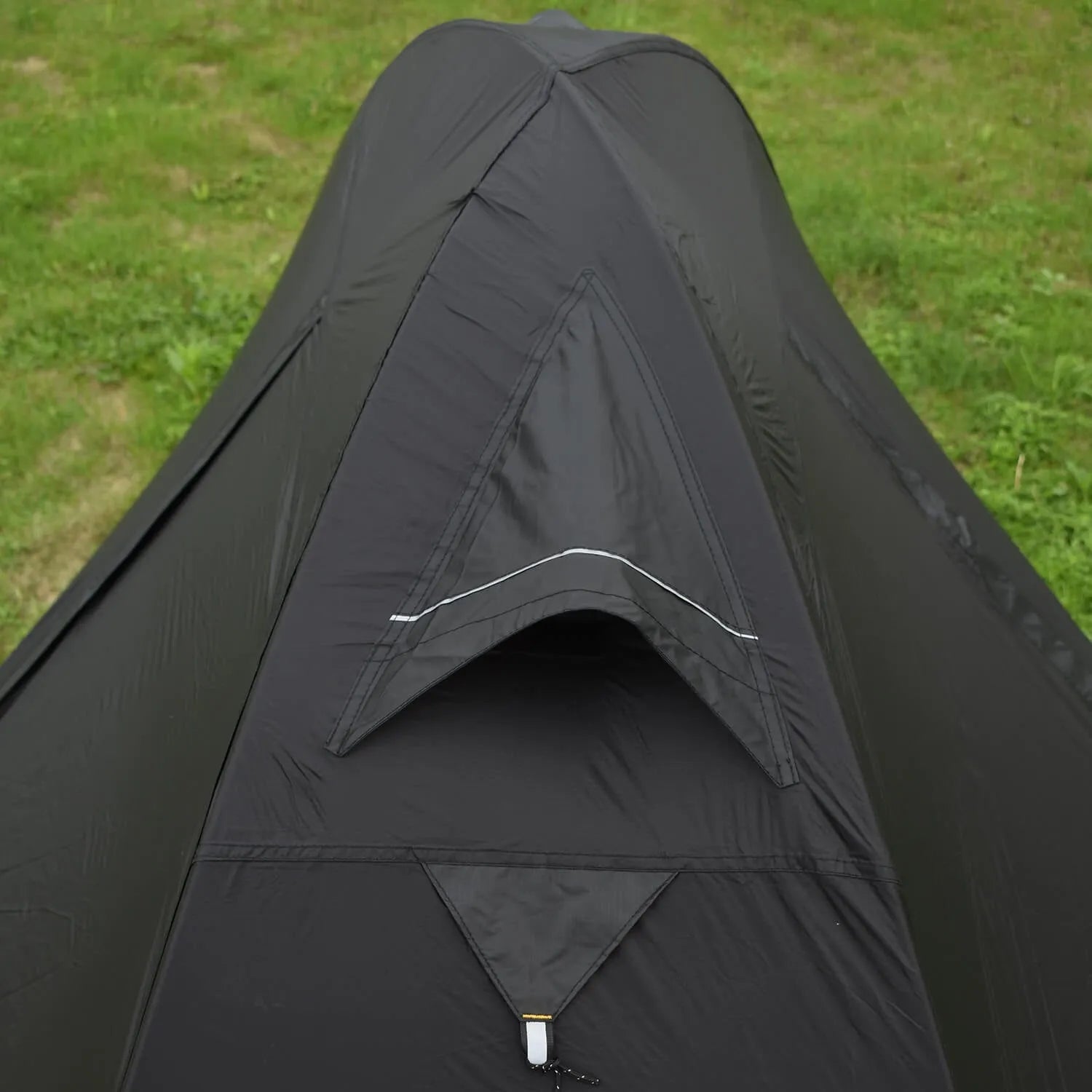 Red single-person backpacking tent with aluminium poles pitched in a forest, showing double-skin design and mesh panel.