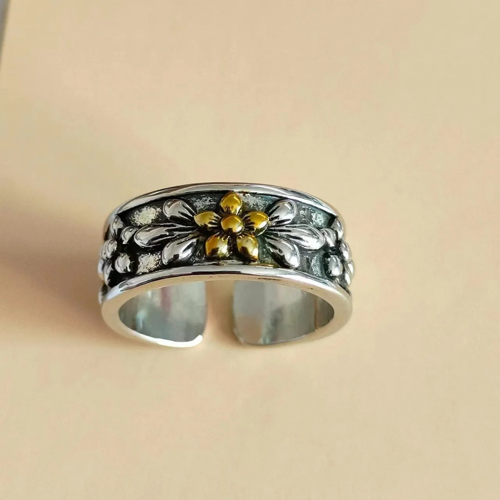 Vintage antique silver gold flower open ring with camellia design on a plain background