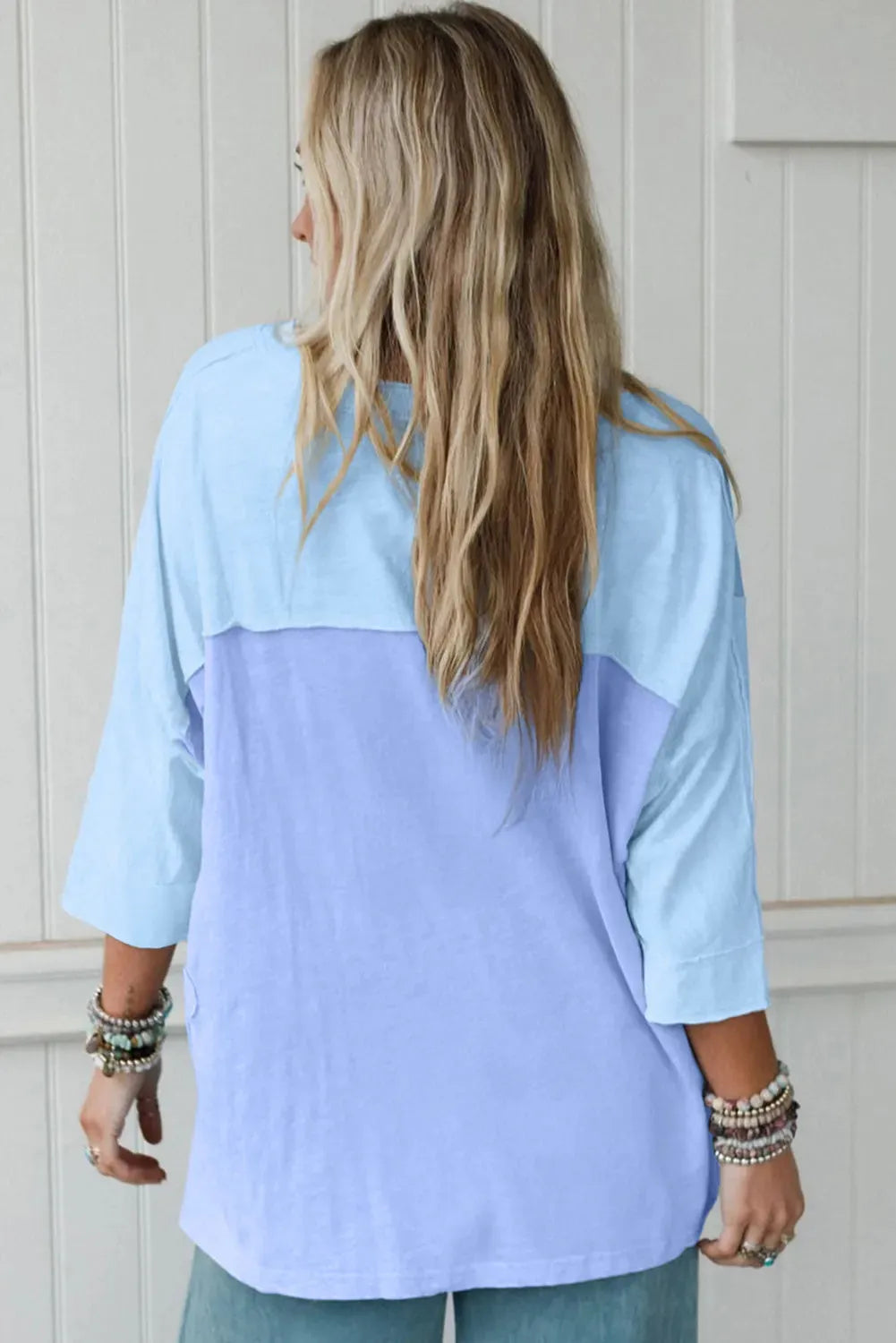 Light blue oversized T shirt with flower patch, exposed seams and bracelet sleeves in sizes S to XL