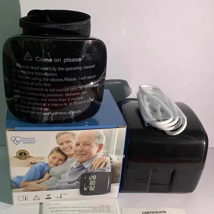 Black rechargeable wrist blood pressure monitor with digital display on a table.