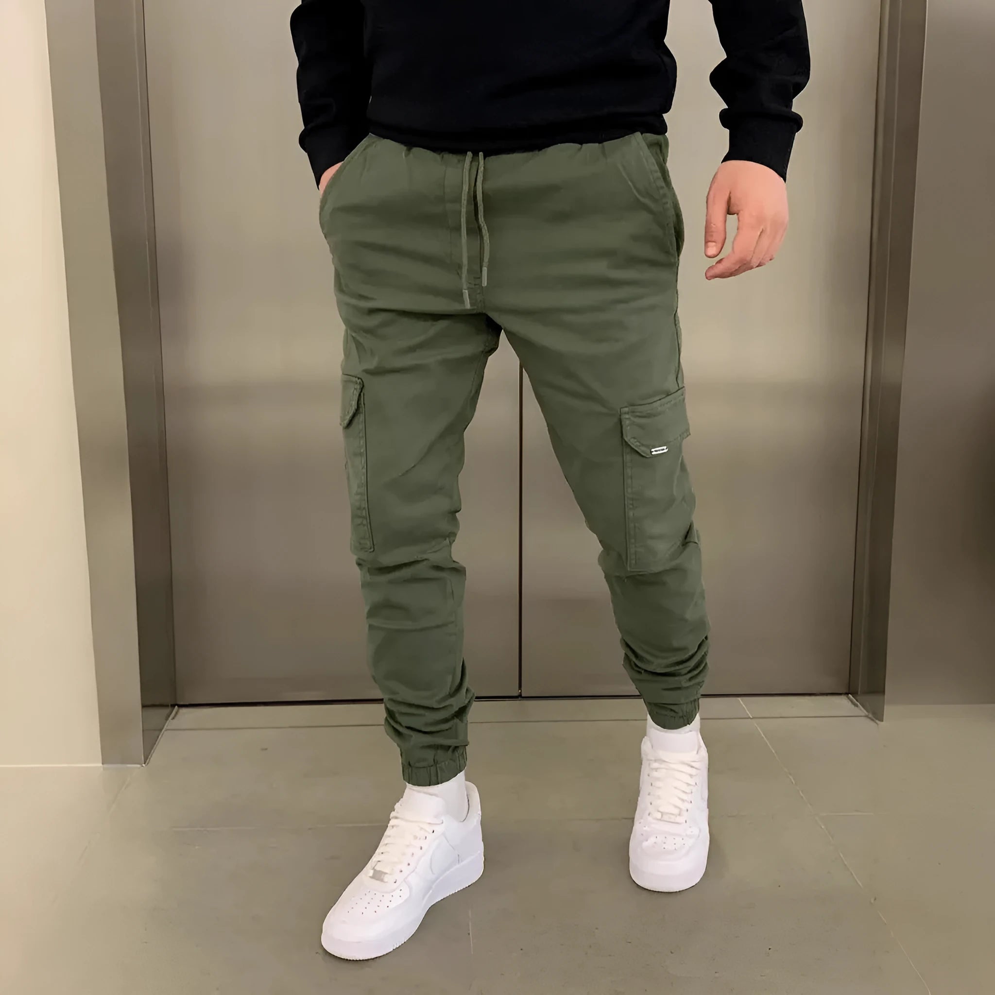 Men's light blue baggy cargo trousers with patch pockets and a lace-up elastic waistband laid flat.