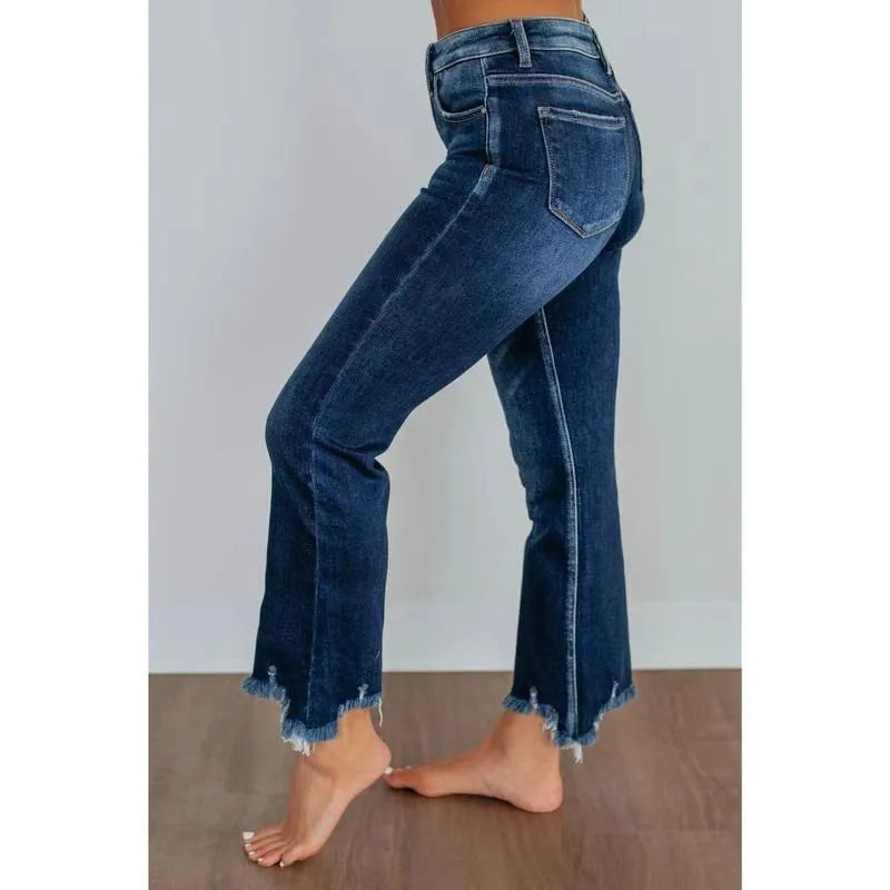 Women's solid colour denim jeans with hand-worn distressing in dark blue, laid flat.