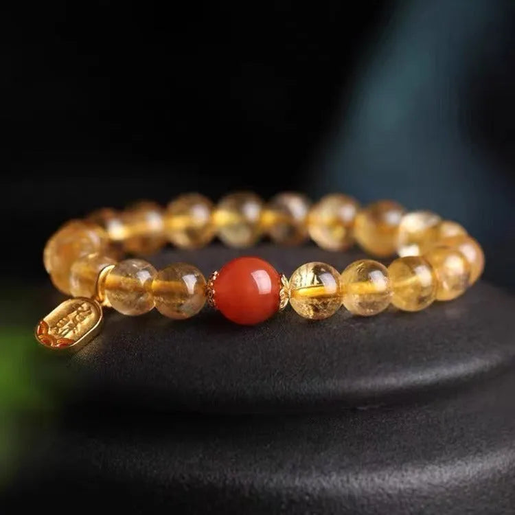 Natural red agate bead bracelet with gold ruby accents on a wrist, showing three bead size options.