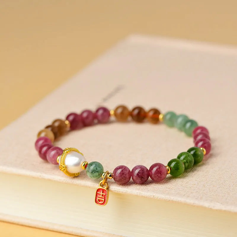 Close-up of a chalcedony bracelet with geometric 6.5mm beads in a tourmaline colour on a wrist.