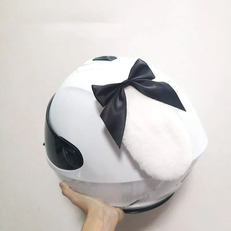 Carbon fibre rabbit ear decoration attached to a black motorcycle helmet, showing clip-on mechanism.