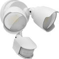 White outdoor LED security flood light with PIR motion sensor mounted on a wall beside a garage door.
