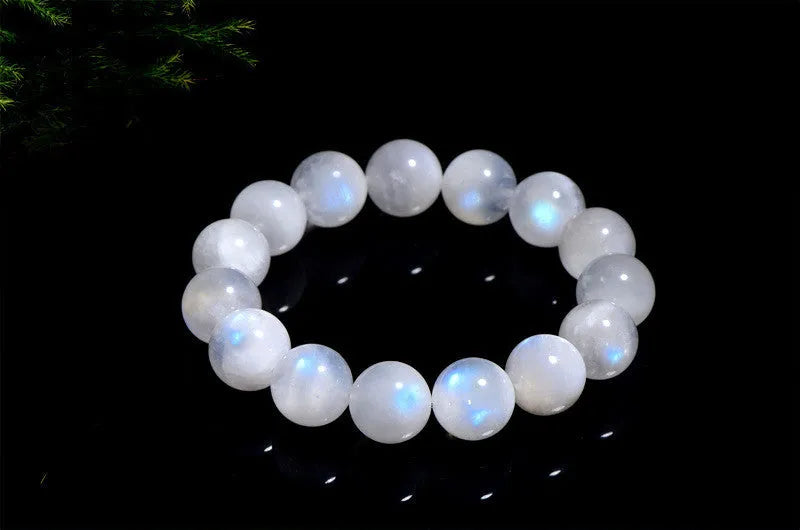 Natural blue and white polished moonstone round bead bracelet on a white background.